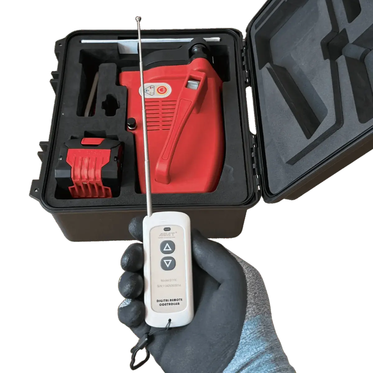Gloved hand holding the ACE-51 remote control with the antenna extended