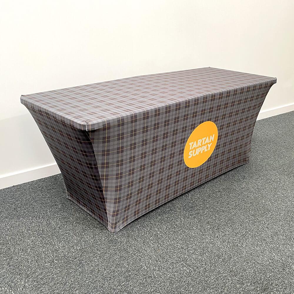 Printed stretch tablecloth supplied with a folding 6ft trestle table — 1800 x 750 x 750mm, 260gsm fire-rated stretch polyester, fully enclosed or open back, £280 ex VAT